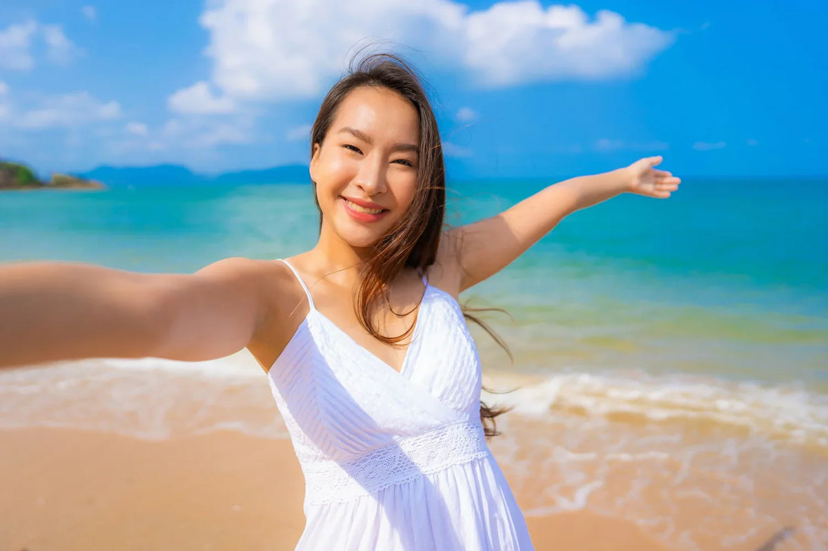 Girl happy on a beach with summer hair tips